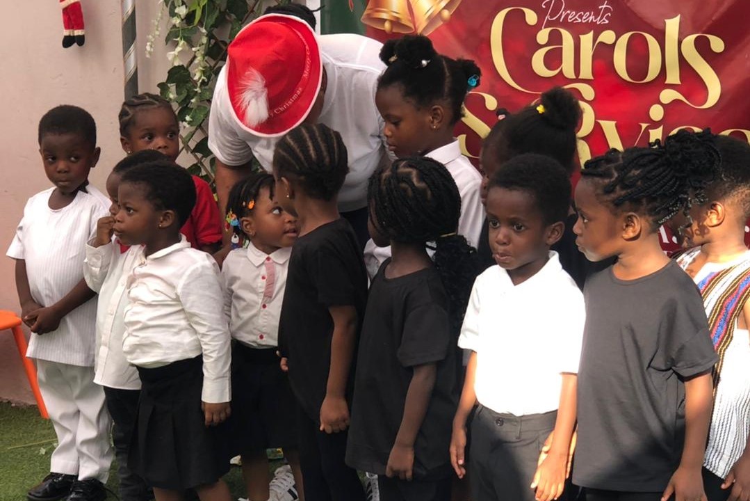 children in african wear holding Ghana flags