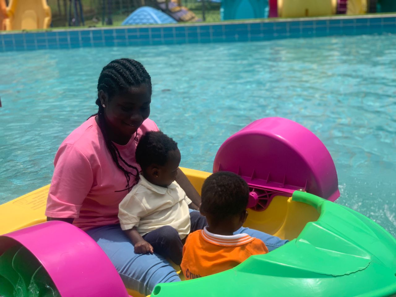 Two children enjoying a boat ride with their
                        teacher