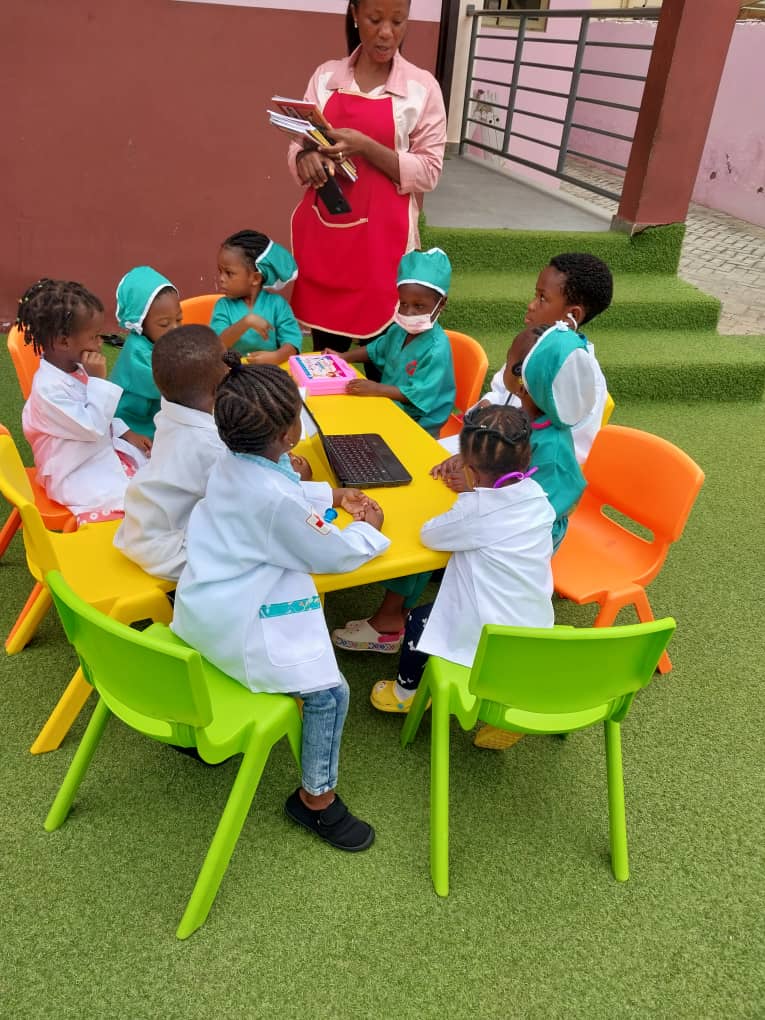 group picture of children in their career day wear sitting around a table