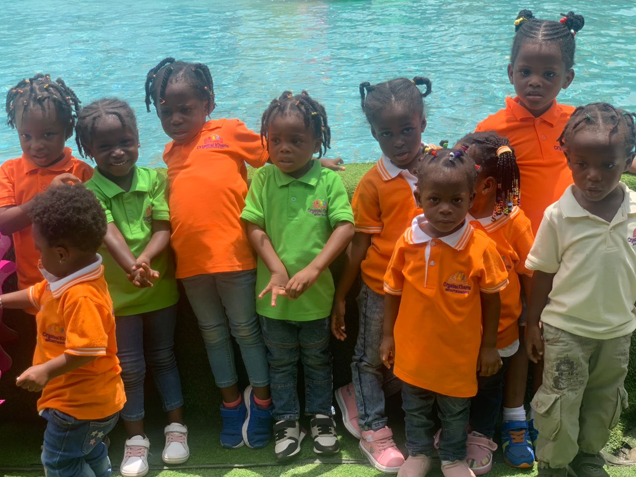 Group picture of children standing in front of a pool